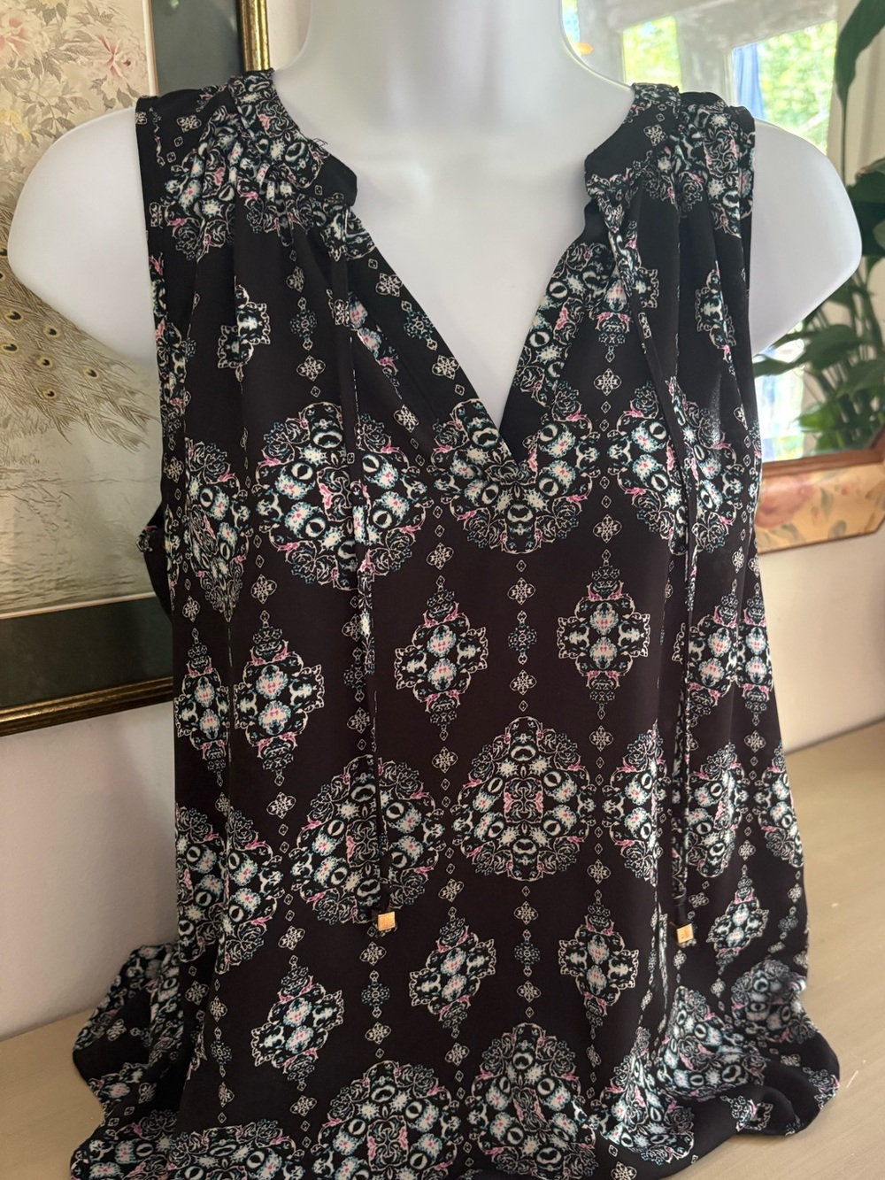 Pink Rose black kaleidoscope blouse features a v-neck and tie-front detail